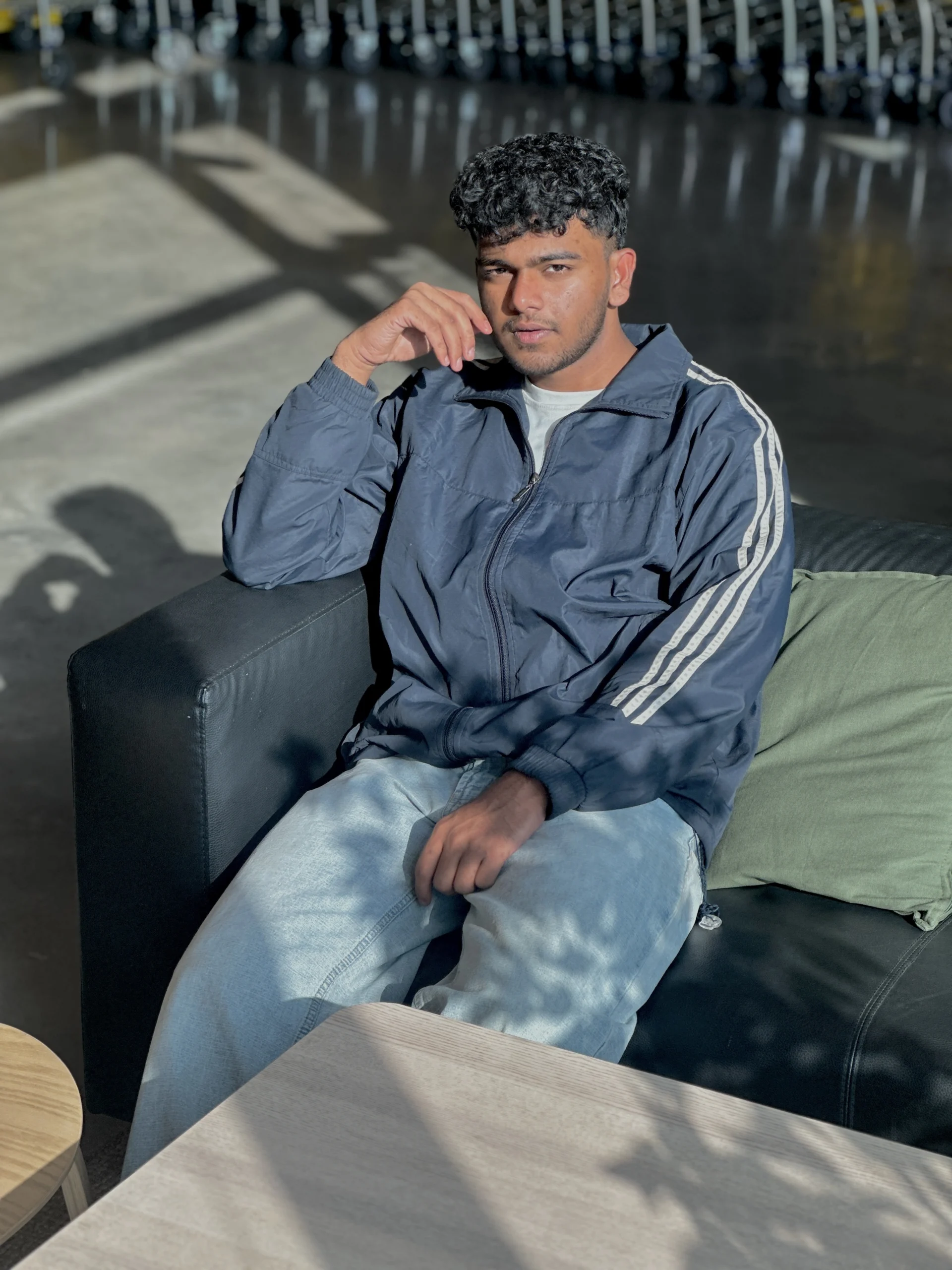 Portrait of Farhan Ali Ahammed, digital marketer and graphic designer, seated in a modern workspace with natural lighting.